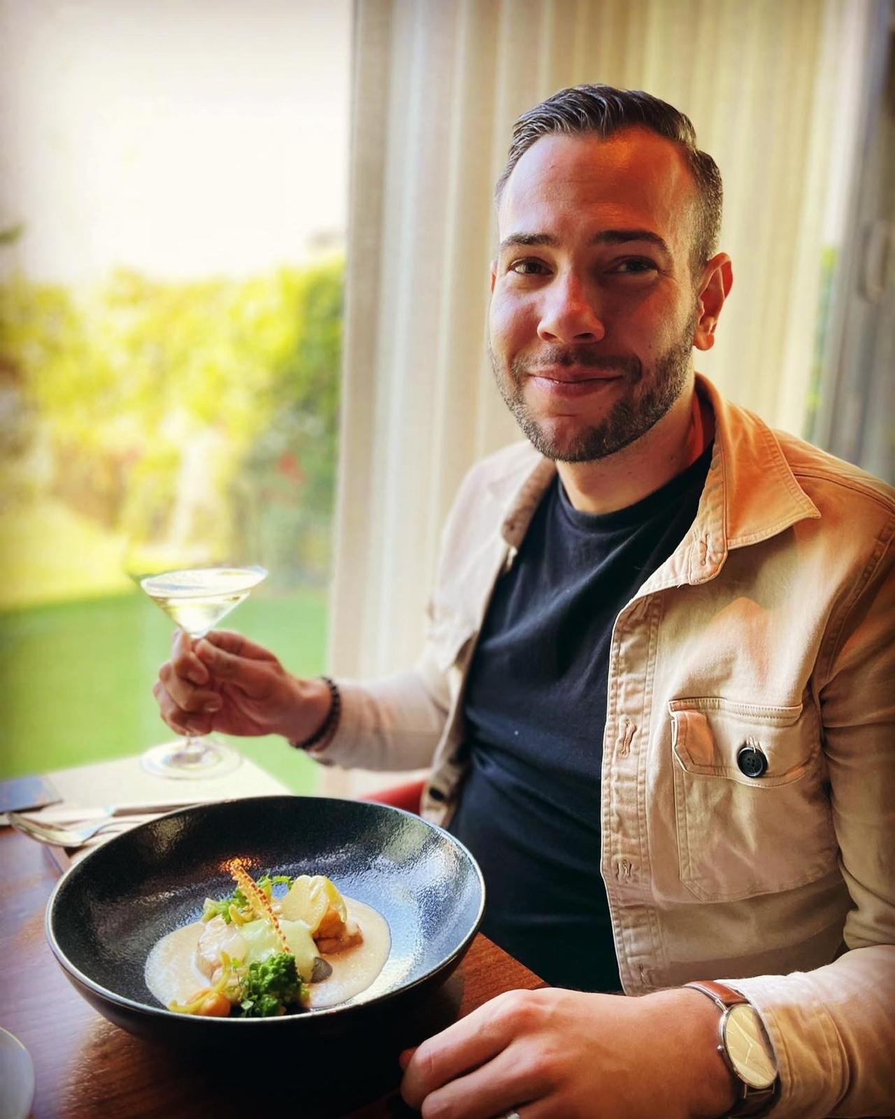 Sven aan tafel met een gerecht en een glas