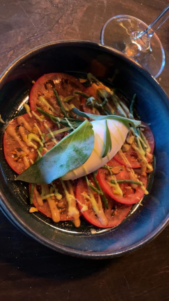 Gerecht met tomaat, mozzarella en zeekraal in een donkere kom