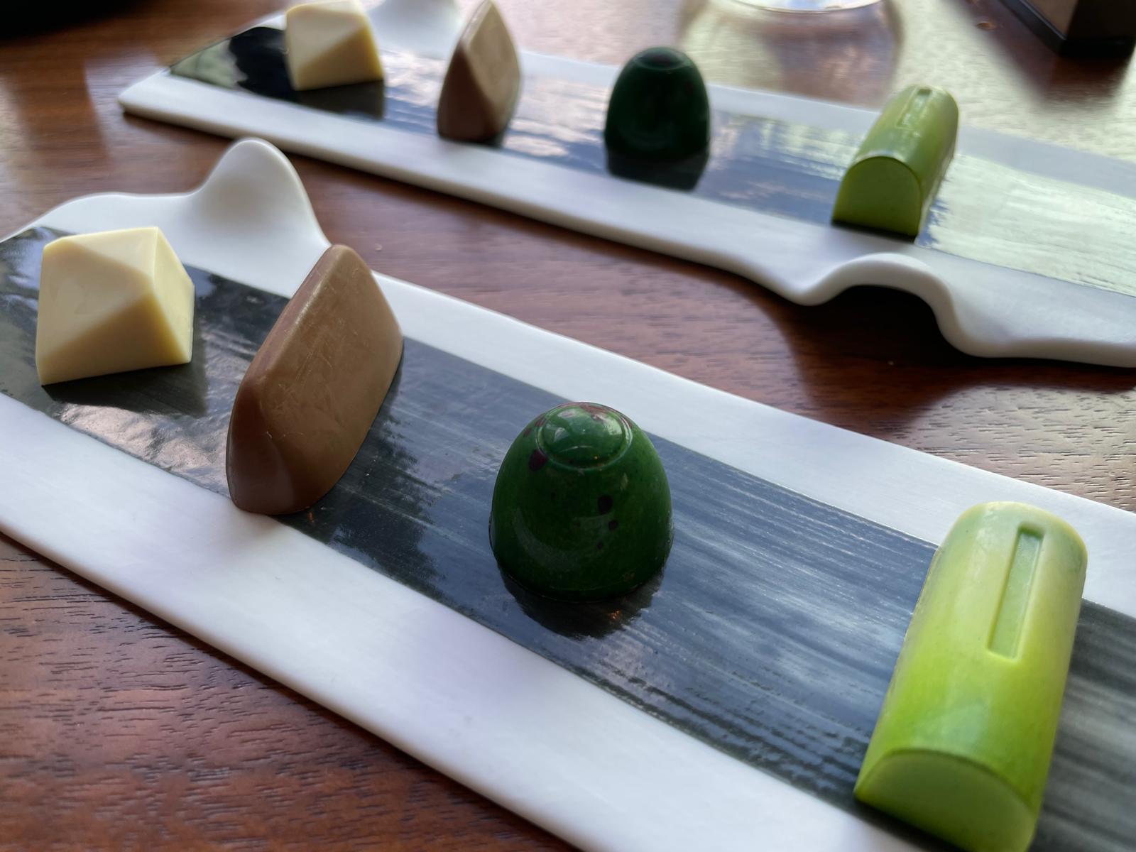 Kleurige bonbons op langwerpige borden aan het einde van het diner