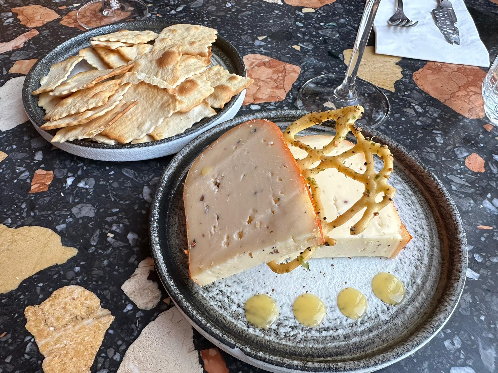 Twee punten kaas met een krokant kantje en crackers op een marmeren tafel