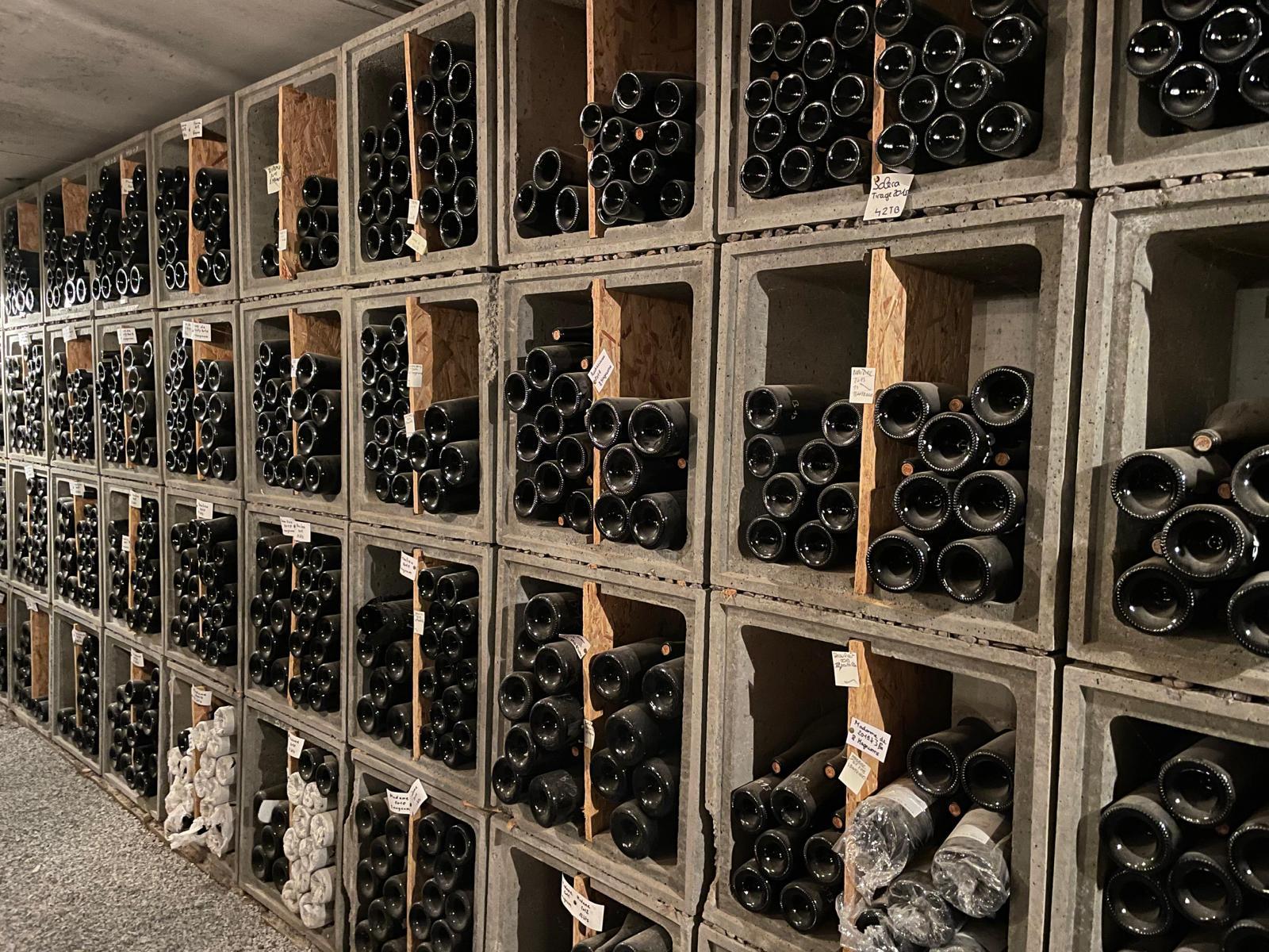 Rekken vol liggende flessen in de flessenkelder van Château de la Selve
