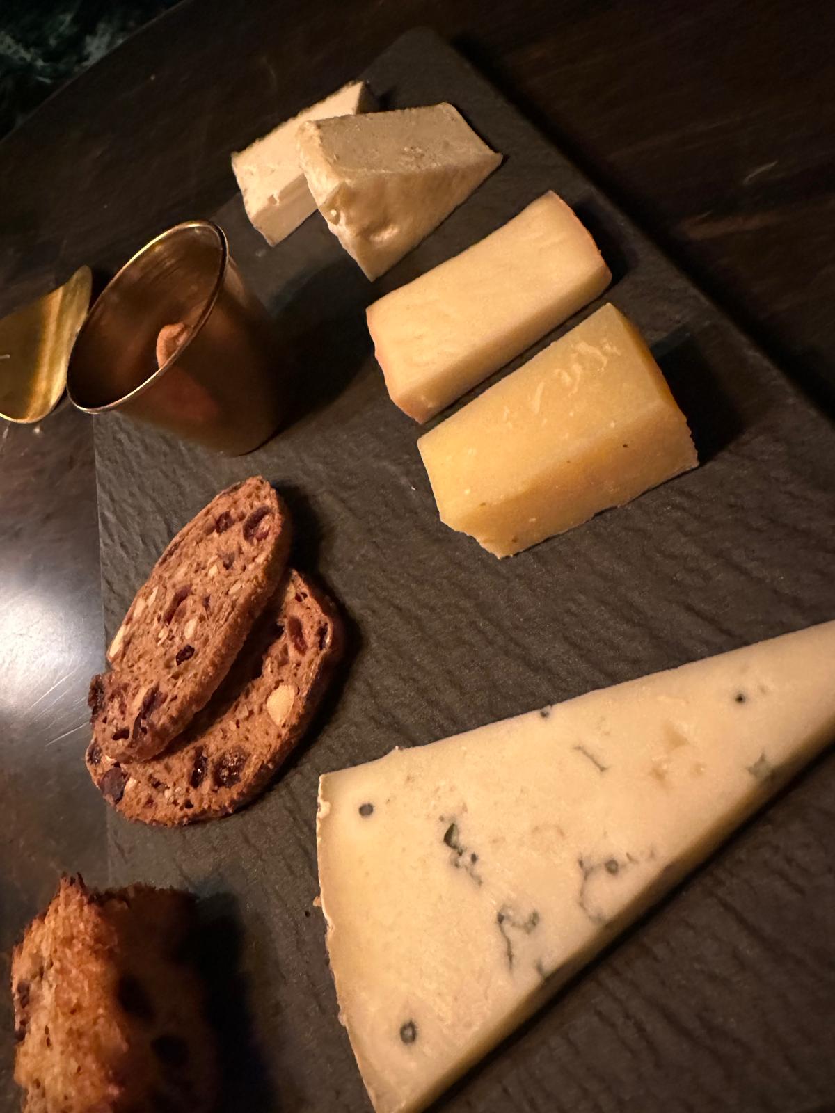 Kaasplank met blauwe kaas, oude kaas en notenbrood op leisteen