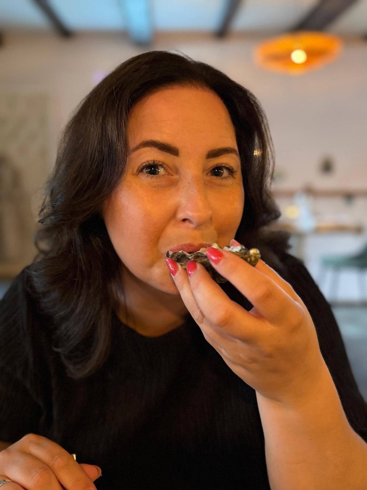 Eva proeft een verse oester aan tafel bij Ultimo in Nijmegen