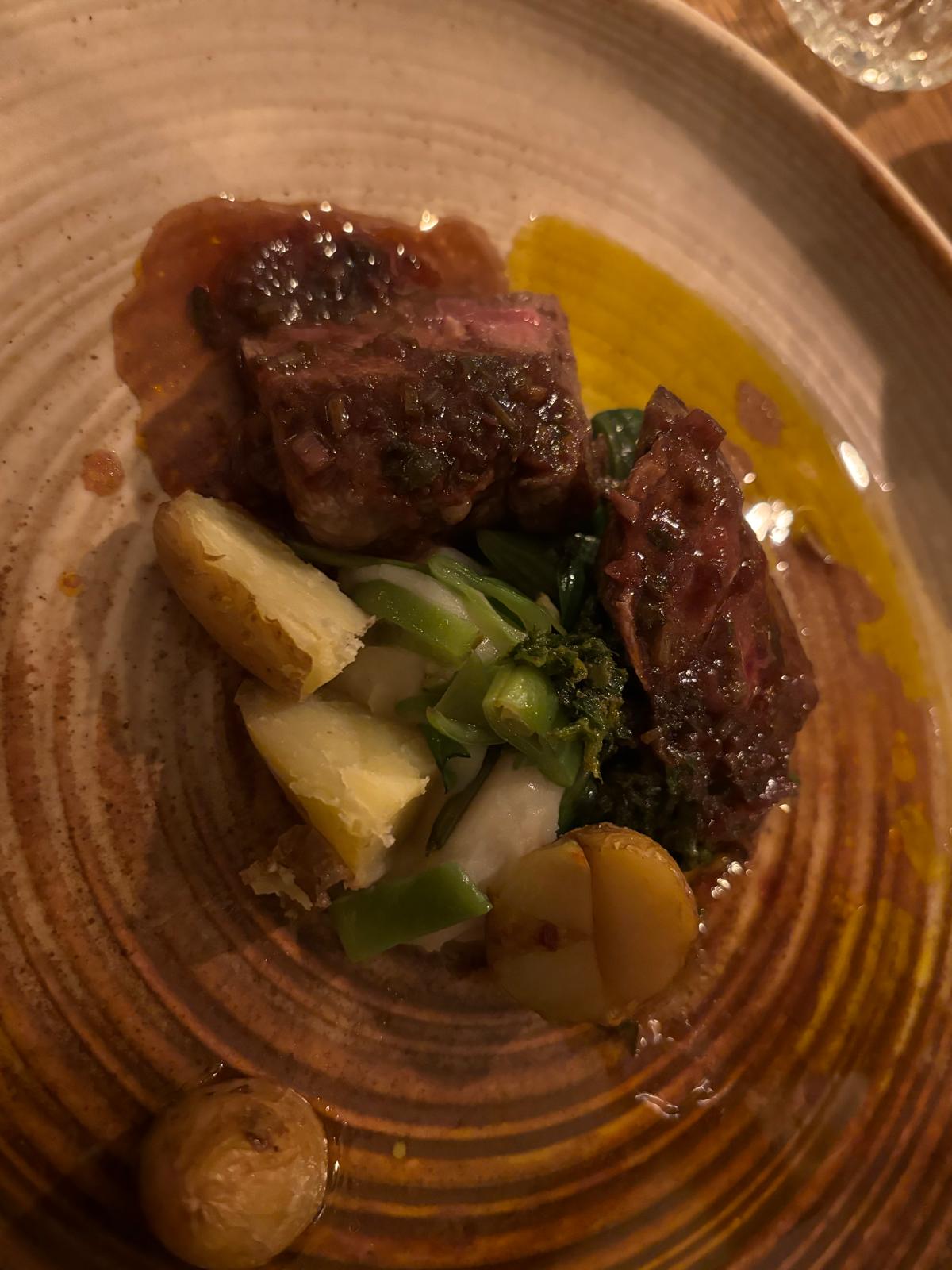 Kort gebakken vlees met krieltjes, groene groenten en een kruidige saus