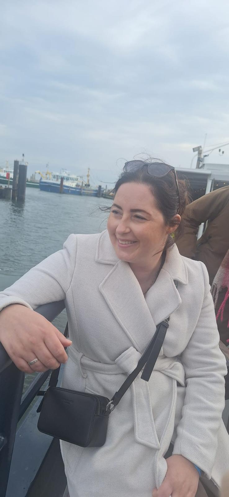 Eva aan boord op de Oosterschelde, met het water en de haven van Yerseke achter haar