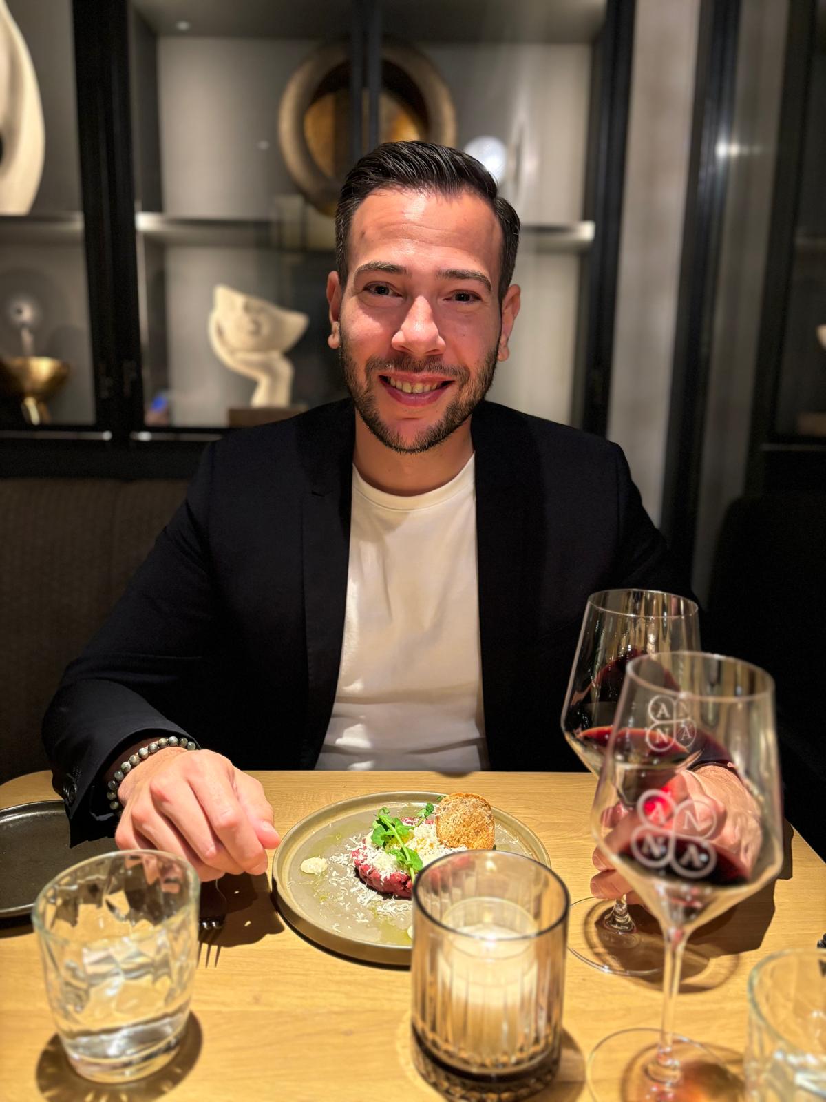 Sven aan tafel bij Parels van Anna met een glas rode wijn en een voorgerecht